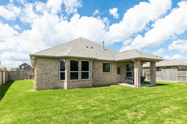 back of house with a patio area and a yard