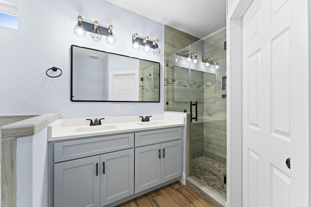 bathroom with vanity, hardwood / wood-style flooring, and a shower with shower door