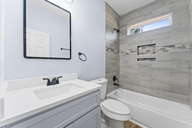 full bathroom with vanity, tiled shower / bath combo, hardwood / wood-style flooring, and toilet