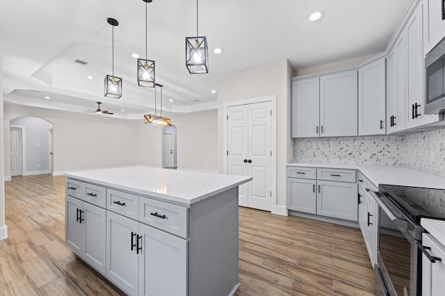 kitchen with ceiling fan, pendant lighting, and wood-type flooring