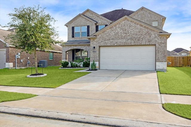 view of front of property featuring a garage, central AC, and a front lawn