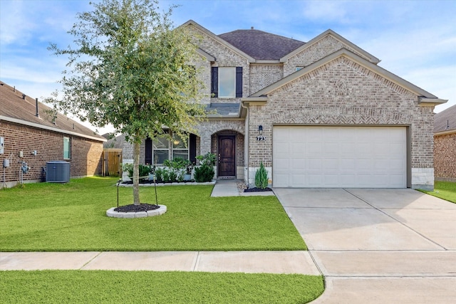 view of front of property with cooling unit, a garage, and a front yard