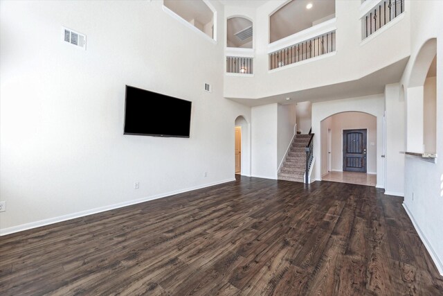 unfurnished living room featuring dark hardwood / wood-style floors and a high ceiling