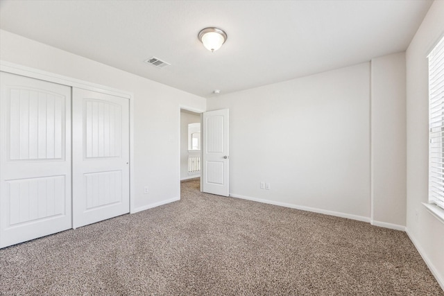 unfurnished bedroom with carpet and a closet