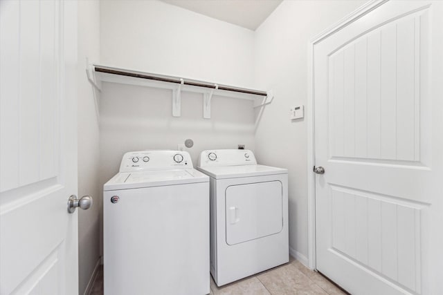 clothes washing area featuring light tile patterned flooring and separate washer and dryer