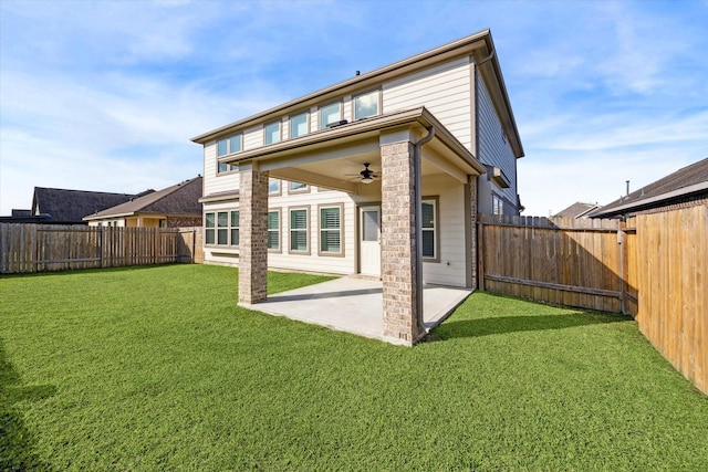 rear view of property with a lawn, ceiling fan, and a patio