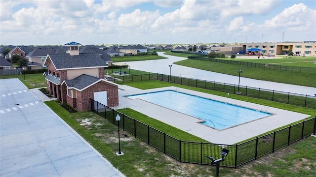 view of pool with a lawn and a water view