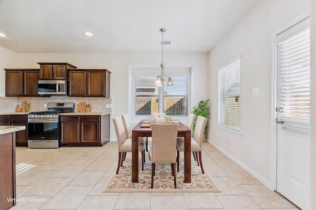 dining room featuring light tile patterned floors and a chandelier