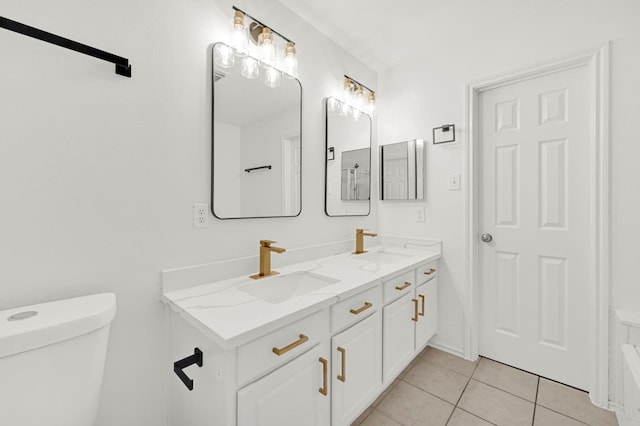 bathroom with tile patterned flooring, vanity, and toilet