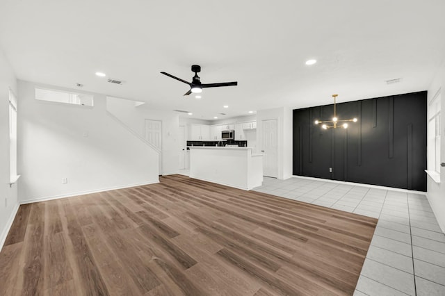 unfurnished living room with light hardwood / wood-style floors and ceiling fan