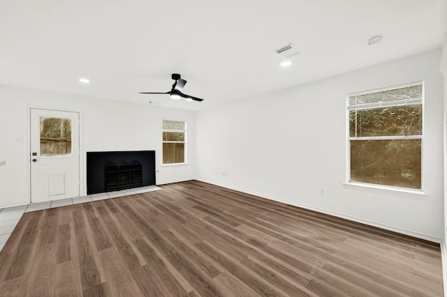 unfurnished living room featuring ceiling fan and hardwood / wood-style floors