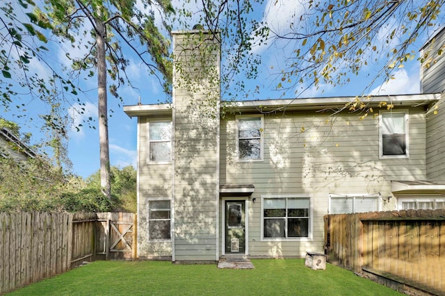 rear view of property featuring a yard