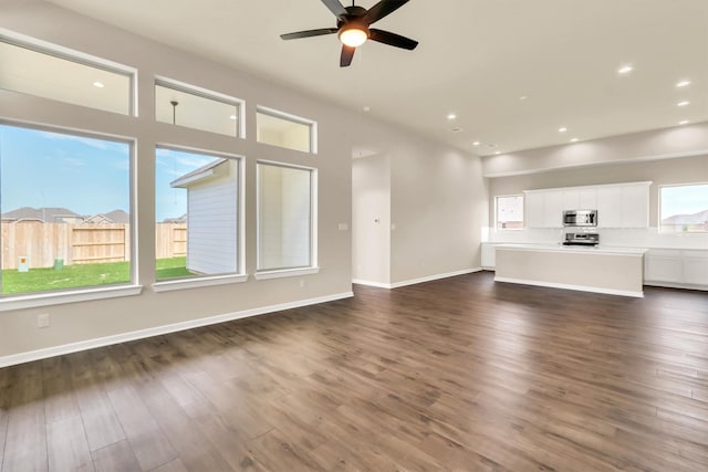 unfurnished living room with ceiling fan and dark wood-type flooring