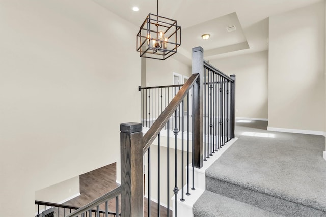 stairs with an inviting chandelier