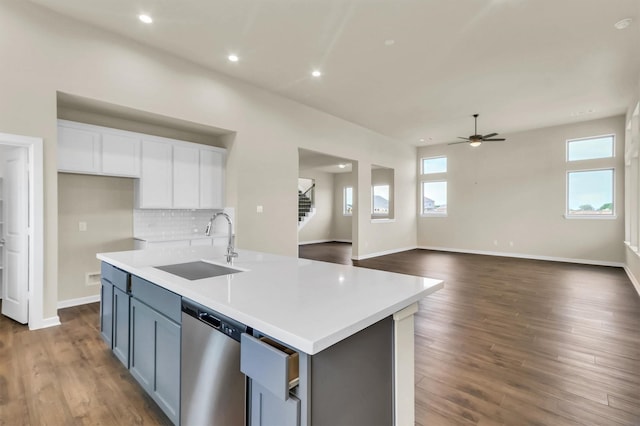 kitchen with a kitchen island with sink, sink, dishwasher, dark hardwood / wood-style floors, and white cabinetry