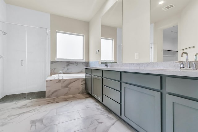 bathroom with tiled bath and vanity