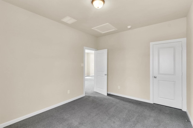 spare room with dark carpet