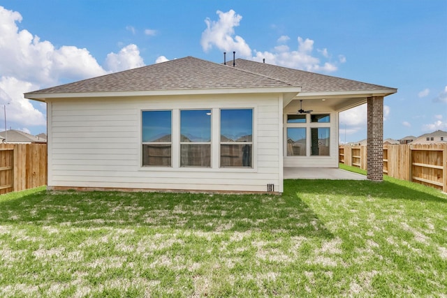 rear view of property with ceiling fan, a yard, and a patio