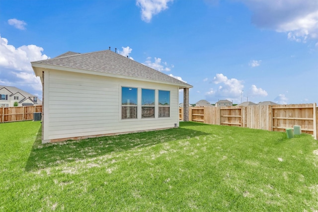 back of property with a lawn and central AC