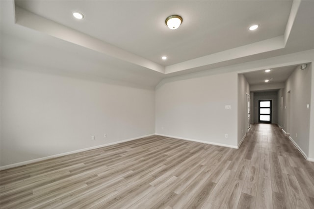 unfurnished room featuring light hardwood / wood-style floors and a raised ceiling