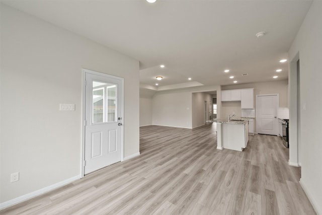 unfurnished living room featuring light hardwood / wood-style floors and sink