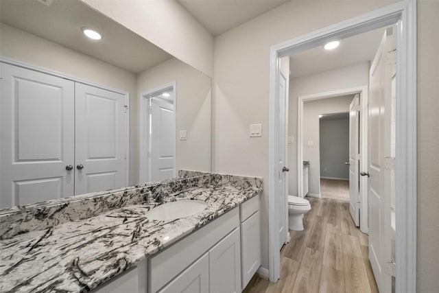 bathroom featuring hardwood / wood-style floors, vanity, and toilet