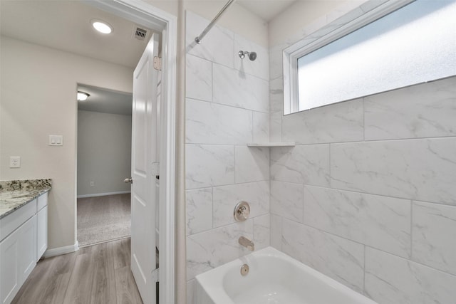 bathroom featuring hardwood / wood-style floors, vanity, and tiled shower / bath