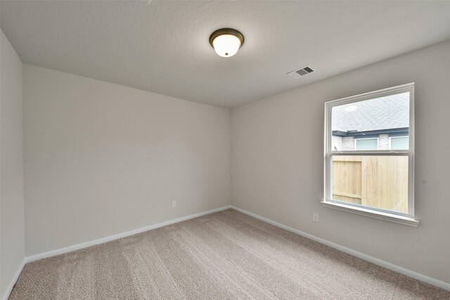 carpeted spare room featuring a textured ceiling