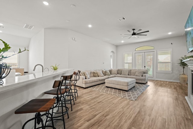 living room featuring ceiling fan and light hardwood / wood-style flooring