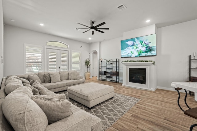 living room with ceiling fan, french doors, and light hardwood / wood-style floors