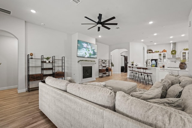 living room with light hardwood / wood-style floors and ceiling fan