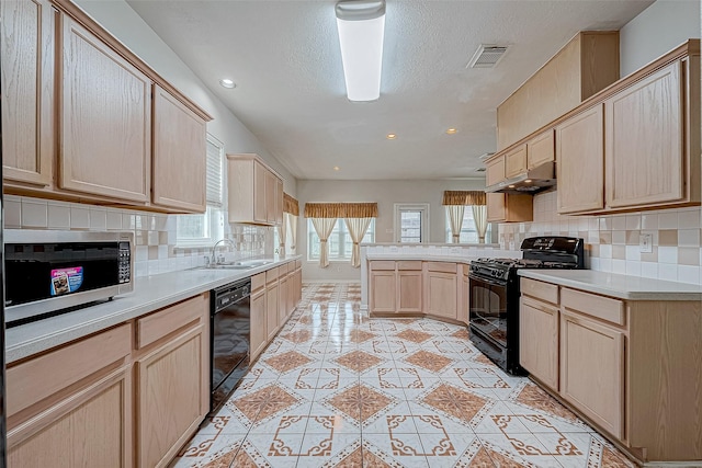 kitchen with light brown cabinets, sink, kitchen peninsula, decorative backsplash, and black appliances