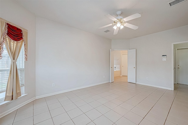 tiled empty room featuring ceiling fan