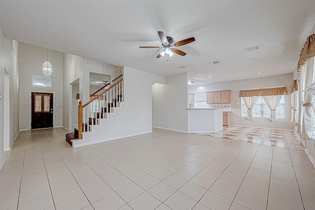 unfurnished living room featuring light tile patterned floors and ceiling fan