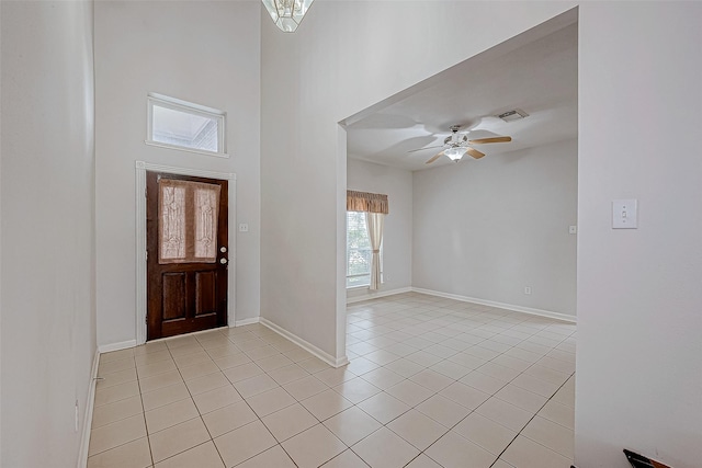 tiled foyer with a towering ceiling and ceiling fan