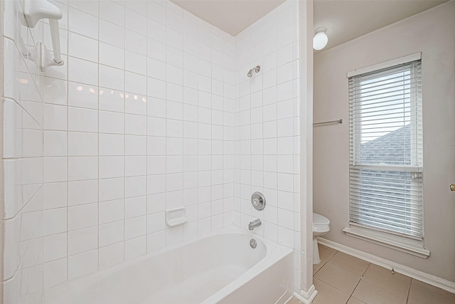 bathroom featuring tile patterned floors, toilet, and tiled shower / bath