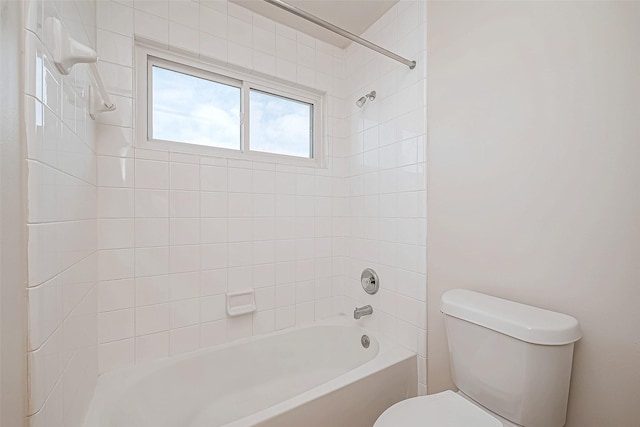 bathroom featuring tiled shower / bath combo and toilet