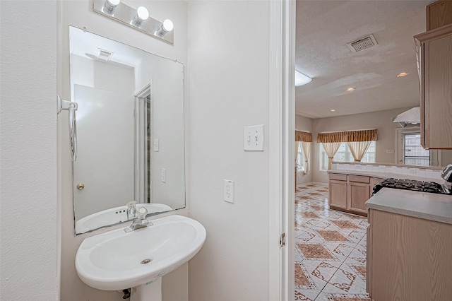 bathroom with a textured ceiling, tile patterned floors, and sink