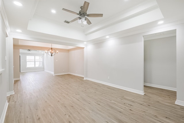 empty room featuring ornamental molding, light hardwood / wood-style floors, and a tray ceiling