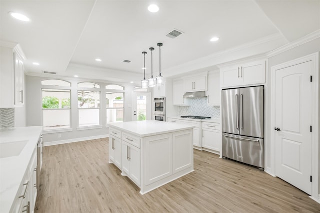 kitchen with white cabinetry, stainless steel appliances, decorative light fixtures, and light hardwood / wood-style floors