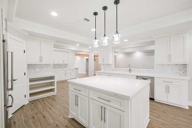 kitchen with white cabinets, decorative backsplash, light hardwood / wood-style floors, appliances with stainless steel finishes, and a kitchen island