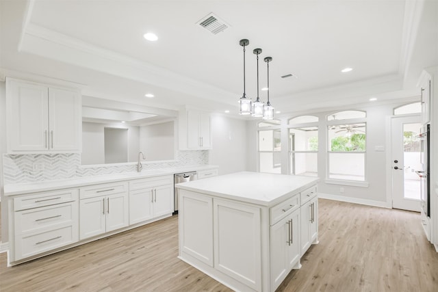 kitchen with decorative backsplash, a center island, white cabinetry, and light hardwood / wood-style flooring