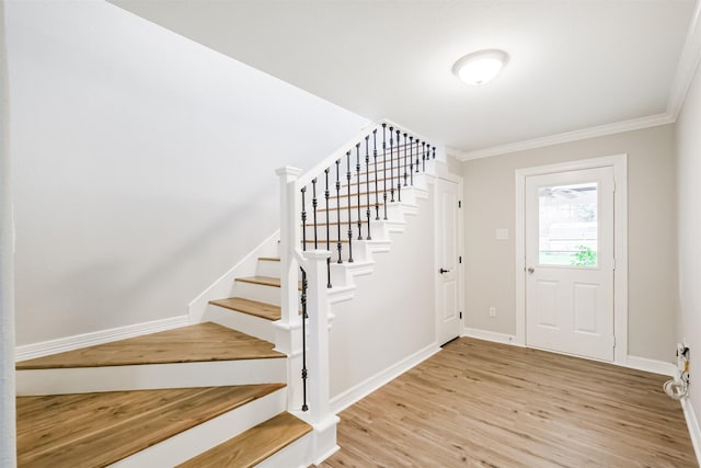 foyer entrance featuring light wood-type flooring and crown molding