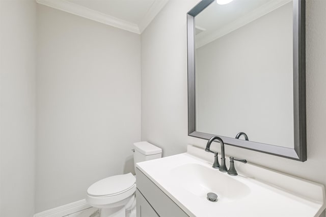 bathroom with vanity, toilet, and ornamental molding