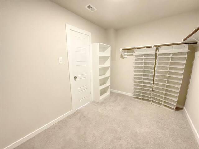 walk in closet featuring light colored carpet