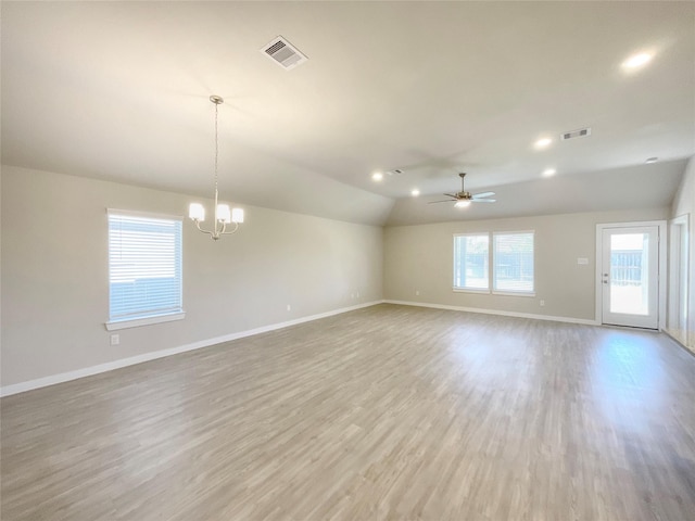 unfurnished room featuring ceiling fan with notable chandelier, light hardwood / wood-style floors, and vaulted ceiling