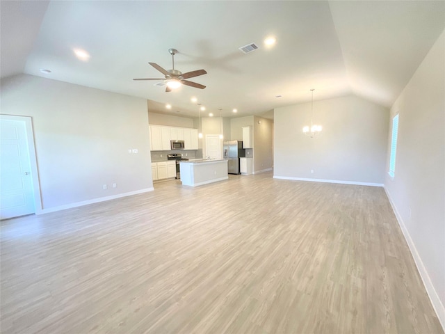 unfurnished living room featuring ceiling fan with notable chandelier, light hardwood / wood-style floors, and lofted ceiling