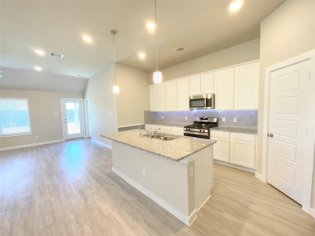 kitchen featuring white cabinets, sink, hanging light fixtures, and appliances with stainless steel finishes