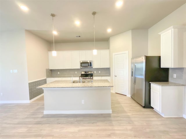 kitchen featuring pendant lighting, light hardwood / wood-style floors, white cabinets, and appliances with stainless steel finishes