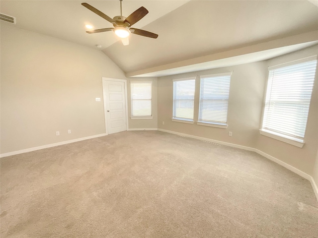 carpeted spare room with plenty of natural light, lofted ceiling, and ceiling fan